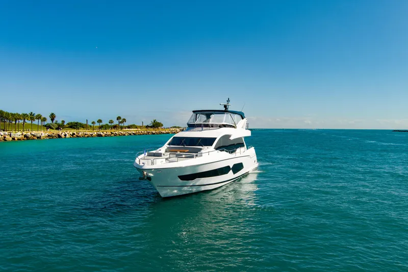 Slide: The Image of 2024 Sunseeker 76 Yacht cruising on clear blue waters under a sunny sky. - 6