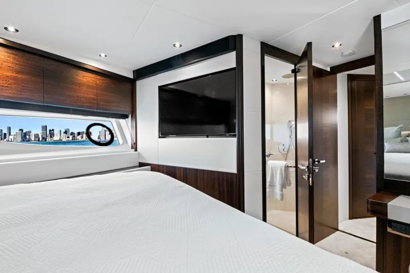 Slide: The Image of Luxurious 2024 Sunseeker 76 Yacht bedroom with city skyline view through window. - 84