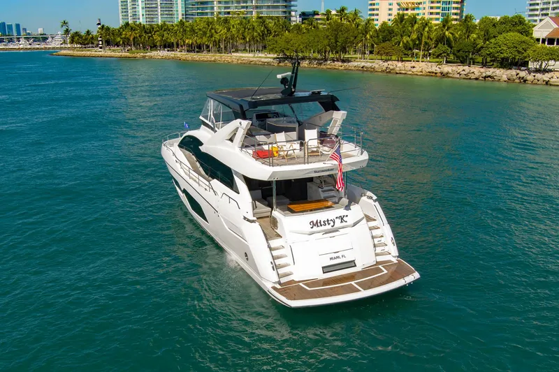 Slide: The Image of 2024 Sunseeker 76 Yacht cruising in sunny waters near a tropical shoreline. - 9