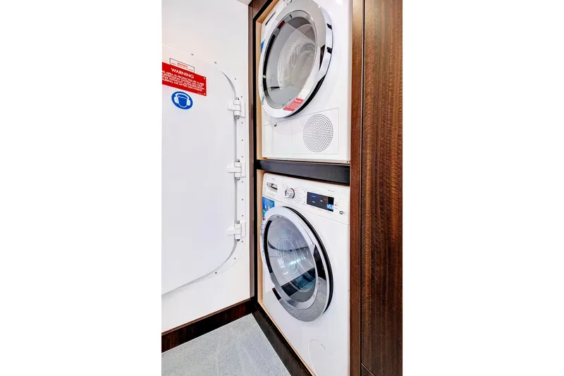Slide: The Image of Laundry area with stacked washer and dryer on 2024 Sunseeker 76 Yacht. - 92