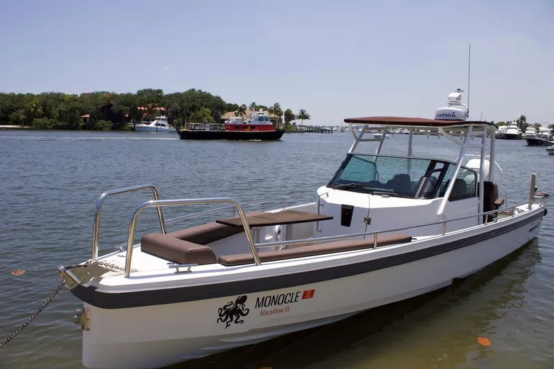 The Image of 2017 Axopar 28TT boat docked on calm water, featuring sleek design and modern amenities. - 1