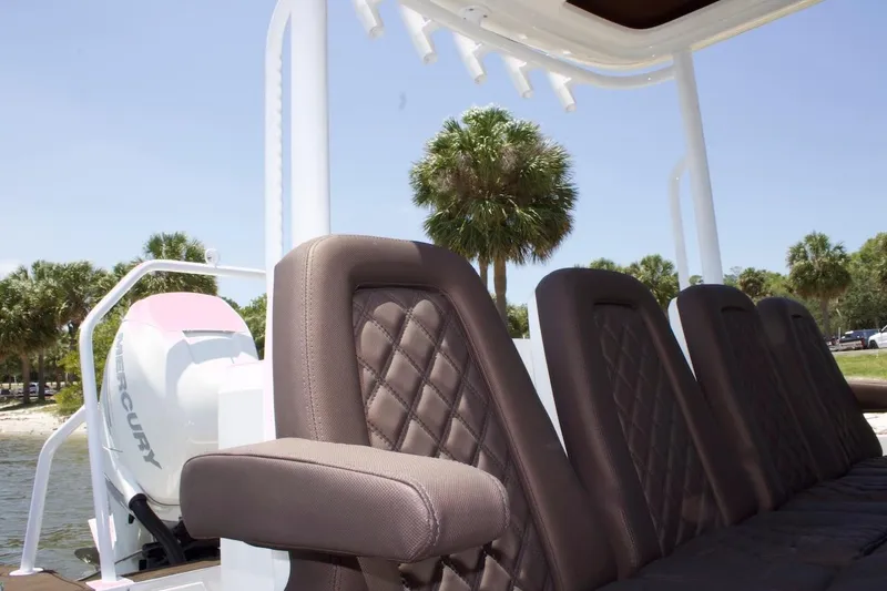 Slide: The Image of 2017 Axopar 28TT boat with Mercury engine, featuring luxurious seating and palm trees in the background. - 12