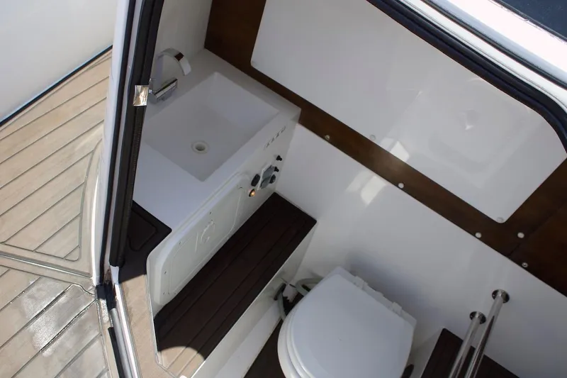 Slide: The Image of 2017 Axopar 28TT boat interior with sink and toilet, featuring wood accents. - 13