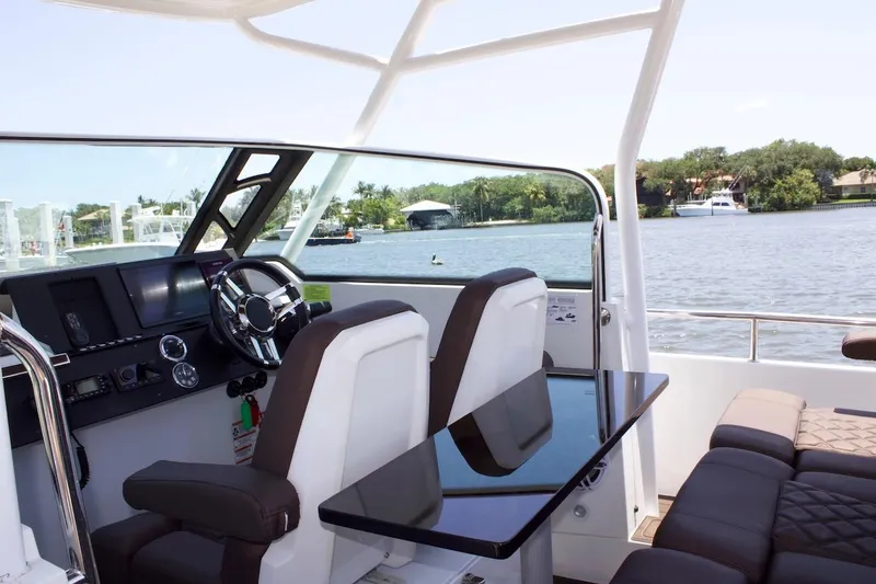 Slide: The Image of 2017 Axopar 28TT boat interior with helm, seating, and water view. - 4