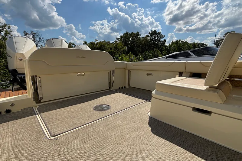 Slide: The Image of 2021 Chris-Craft Calypso 35 boat interior with seating and outboard motors under a cloudy sky. - 14