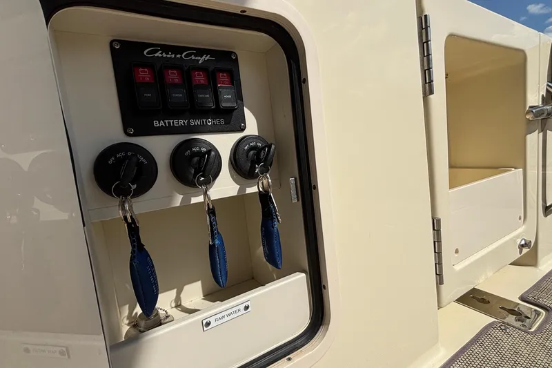 Slide: The Image of Battery switches on 2021 Chris-Craft Calypso 35 boat, featuring key slots and storage compartment. - 15