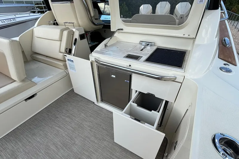 Slide: The Image of 2021 Chris-Craft Calypso 35 boat interior with kitchenette, featuring sink, grill, and storage. - 18