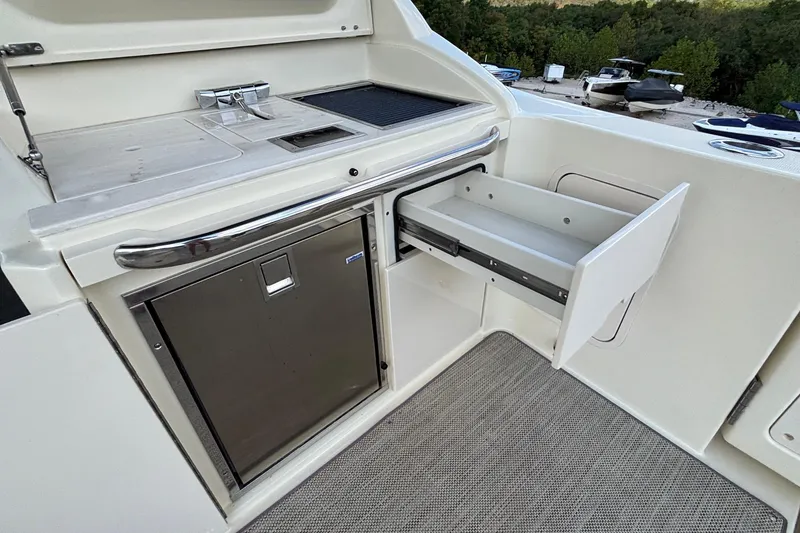 Slide: The Image of 2021 Chris-Craft Calypso 35 boat kitchen area with stainless steel fridge and open drawer. - 19