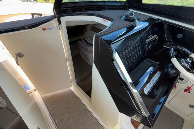 Slide: The Image of 2021 Chris-Craft Calypso 35 helm with open cabin door, showcasing modern controls. - 41