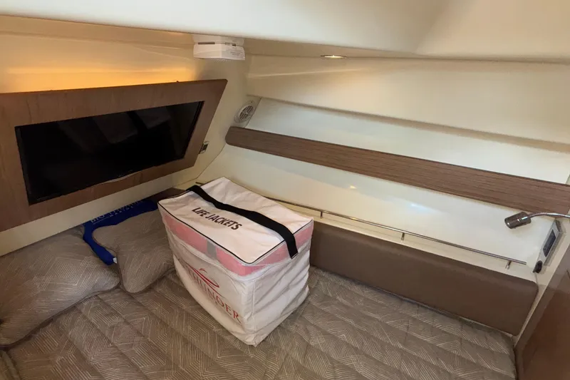 Slide: The Image of 2021 Chris-Craft Calypso 35 cabin interior with TV and life jackets. - 42