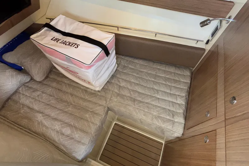 Slide: The Image of 2021 Chris-Craft Calypso 35 cabin interior with life jackets and cushioned seating. - 43