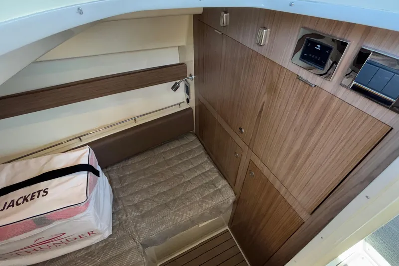 Slide: The Image of 2021 Chris-Craft Calypso 35 cabin interior with wood paneling and storage compartments. - 44