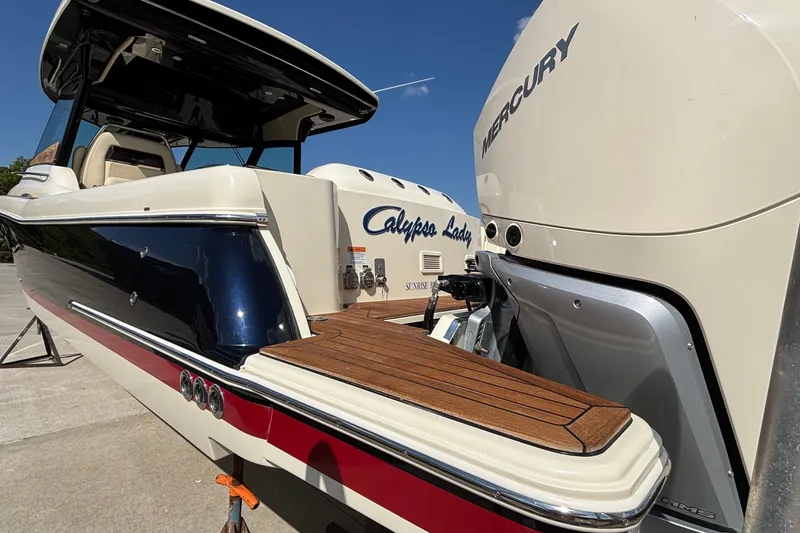 Slide: The Image of 2021 Chris-Craft Calypso 35 boat with Mercury engine, featuring sleek design and wooden deck. - 5