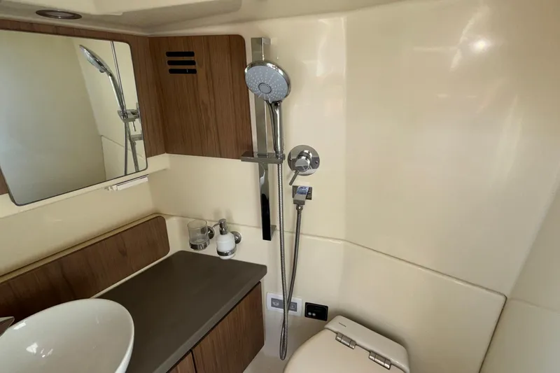 Slide: The Image of 2021 Chris-Craft Calypso 35 bathroom with modern fixtures and wooden accents. - 50