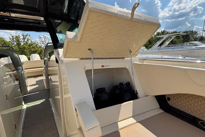Slide: The Image of 2021 Chris-Craft Calypso 35 boat storage compartment open under sunny skies. - 59