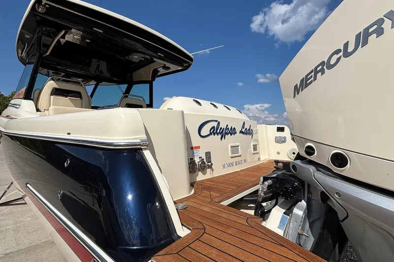 Slide: The Image of 2021 Chris-Craft Calypso 35 boat with Mercury engine, docked under clear blue sky. - 6