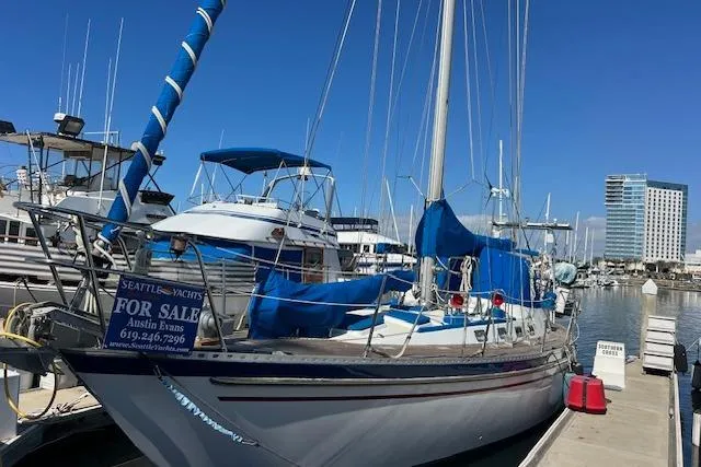 The Image of 1987 Tayana Vancouver 42 sailboat docked, for sale, with blue covers and clear sky. - 1