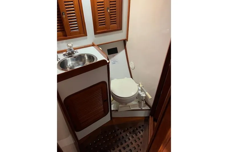 Slide: The Image of 1987 Tayana Vancouver 42 yacht bathroom with sink, toilet, and wooden cabinetry. - 19