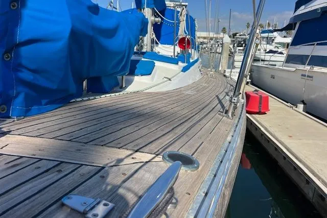 Slide: The Image of 1987 Tayana Vancouver 42 sailboat with wooden deck and blue covers at marina. - 3