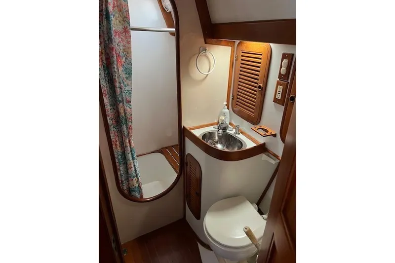 Slide: The Image of 1987 Tayana Vancouver 42 yacht bathroom with sink, toilet, and floral shower curtain. - 30