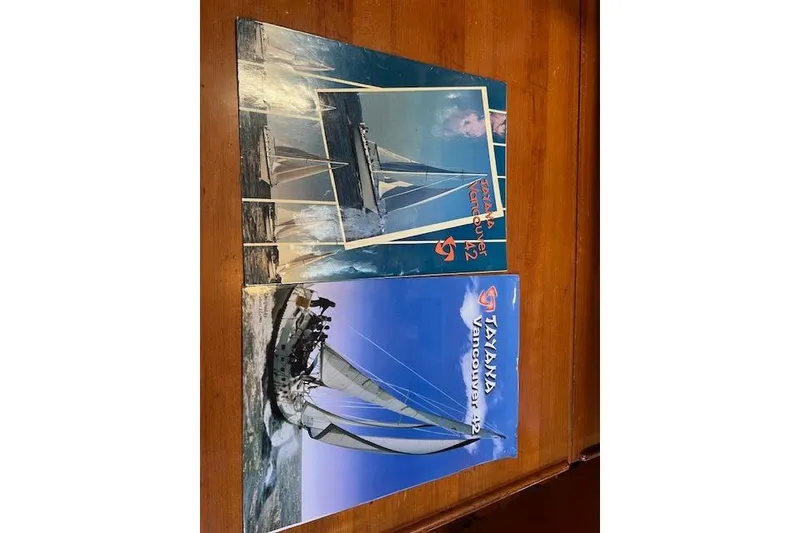 Slide: The Image of Brochures of 1987 Tayana Vancouver 42 sailboat on wooden table. - 31
