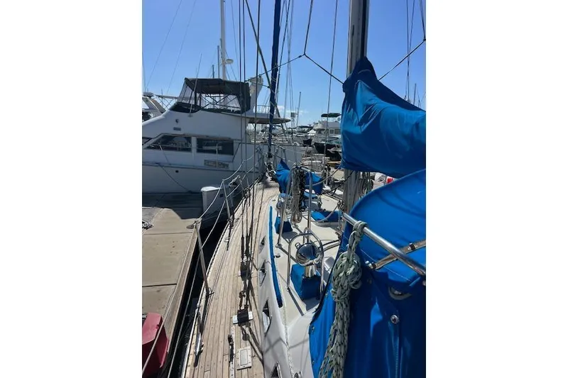 Slide: The Image of 1987 Tayana Vancouver 42 sailboat docked, featuring blue covers and rigging. - 8
