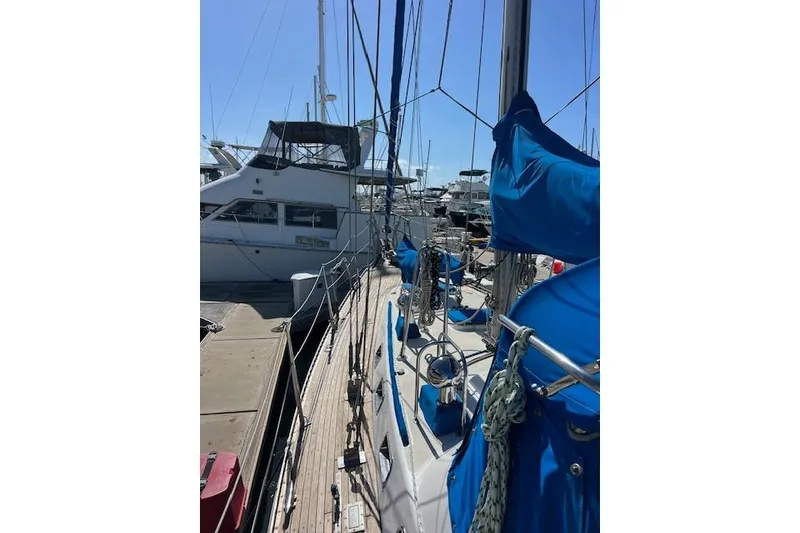 Slide: The Image of 1987 Tayana Vancouver 42 sailboat docked, featuring blue covers and rigging. - 9