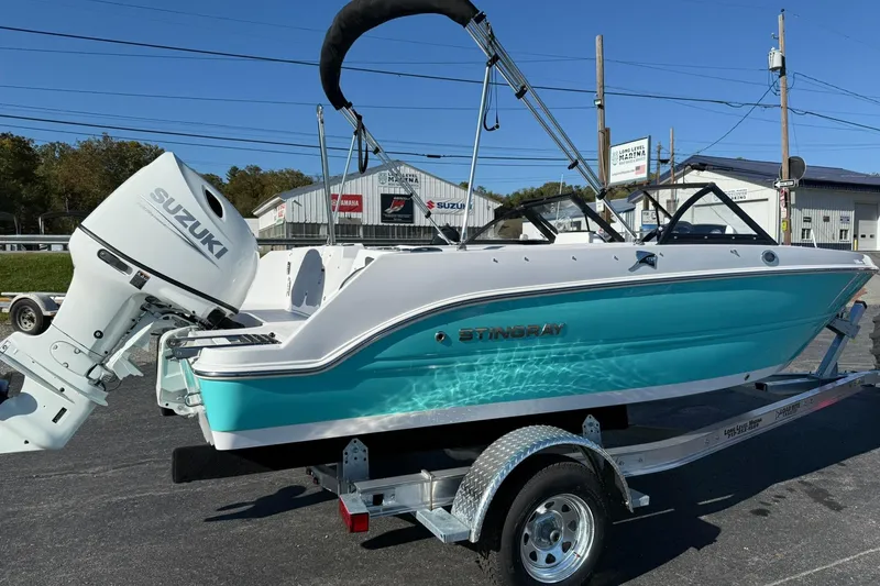 Slide: The Image of 2026 Stingray 172 DC boat with Suzuki engine on trailer, parked outdoors. - 4