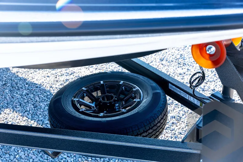 Slide: The Image of 2026 Skeeter ZXE21 trailer with spare tire on gravel surface. - 12