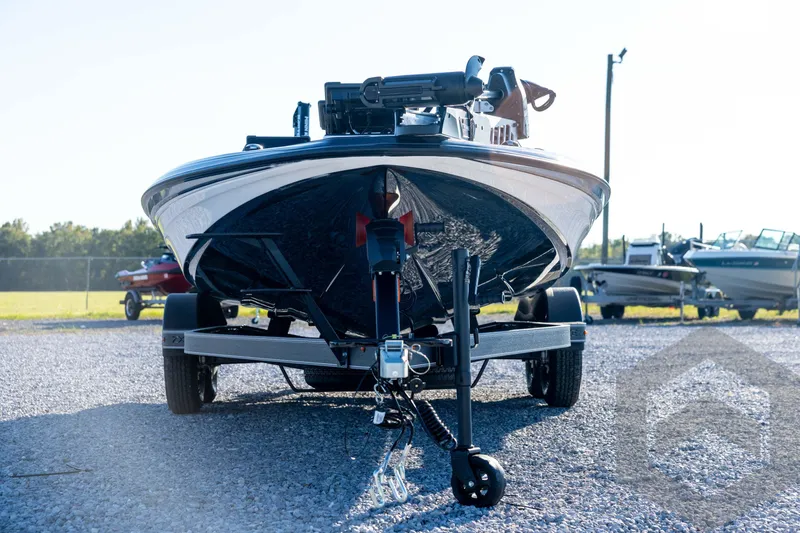 Slide: The Image of 2026 Skeeter ZXE21 boat on trailer, parked on gravel lot, front view. - 2