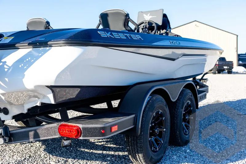 Slide: The Image of 2026 Skeeter ZXE21 boat on trailer, parked on gravel, side view. - 20