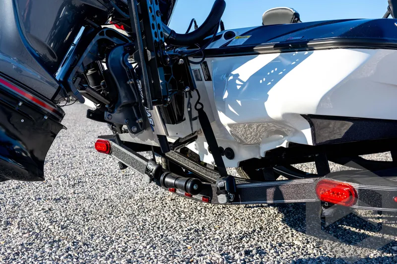 Slide: The Image of 2026 Skeeter ZXE21 boat trailer with motor, parked on gravel. - 21