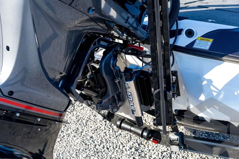 Slide: The Image of 2026 Skeeter ZXE21 boat engine detail with hydraulic components on gravel surface. - 22