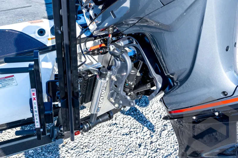 Slide: The Image of 2026 Skeeter ZXE21 boat engine close-up with hydraulic components on gravel surface. - 25