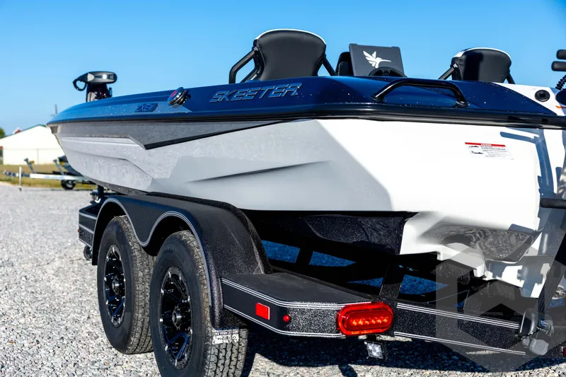 Slide: The Image of 2026 Skeeter ZXE21 boat on trailer, showcasing sleek design and dual wheels. - 27