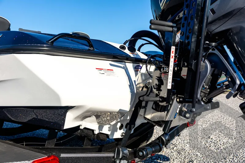 Slide: The Image of 2026 Skeeter ZXE21 boat detail with motor and extender mechanism, under clear blue sky. - 28