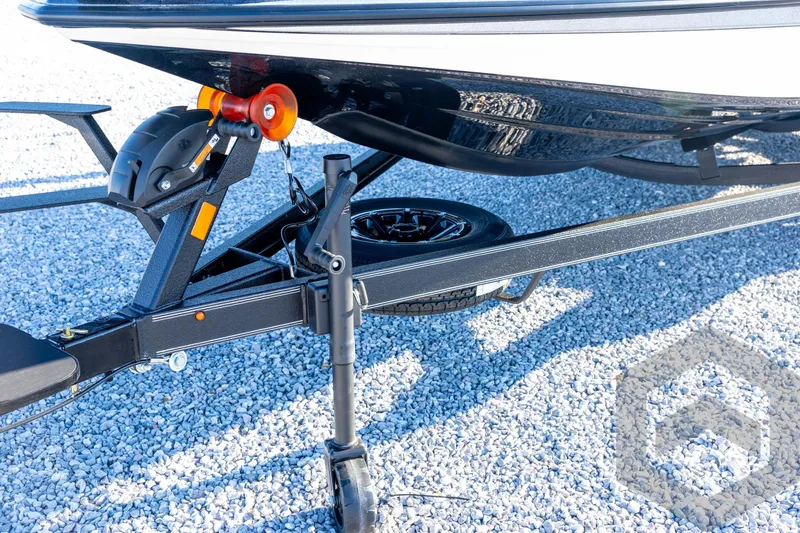 Slide: The Image of 2026 Skeeter ZXE21 boat trailer on gravel, featuring sturdy support and wheel detail. - 37