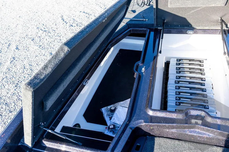Slide: The Image of Open storage compartment in 2026 Skeeter ZXE21 boat, showcasing organized tackle boxes. - 53