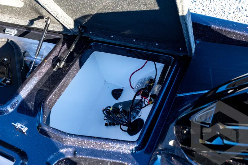 Slide: The Image of Open storage compartment in 2026 Skeeter ZXE21 boat, showing wiring and components. - 57