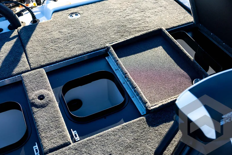 Slide: The Image of 2026 Skeeter ZXE21 boat deck with storage compartments and carpeted surface. - 76