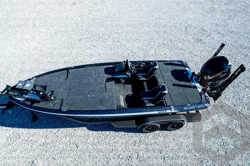 Slide: The Image of 2026 Skeeter ZXE21 fishing boat on gravel, featuring dual seats and powerful outboard motor. - 87