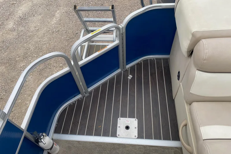 Slide: The Image of 2013 Sweetwater 2286 boat interior with blue panels, beige seating, and metal ladder. - 13