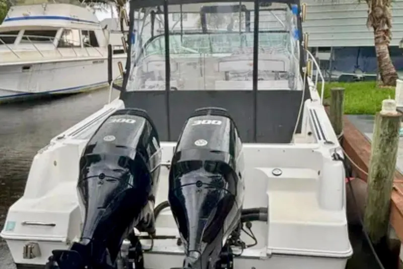 Slide: The Image of 2002 Wellcraft 290 Coastal boat with dual outboard engines docked at marina. - 16