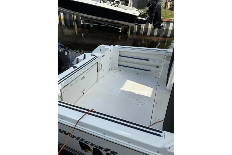 Slide: The Image of 2002 Wellcraft 290 Coastal boat deck, spacious and clean, docked by the water. - 21