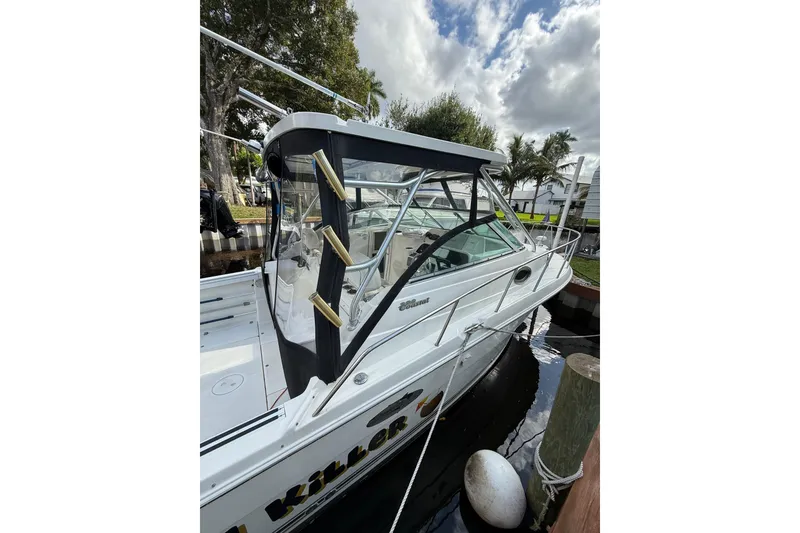 Slide: The Image of 2002 Wellcraft 290 Coastal boat docked, featuring a sleek design and enclosed cabin. - 23