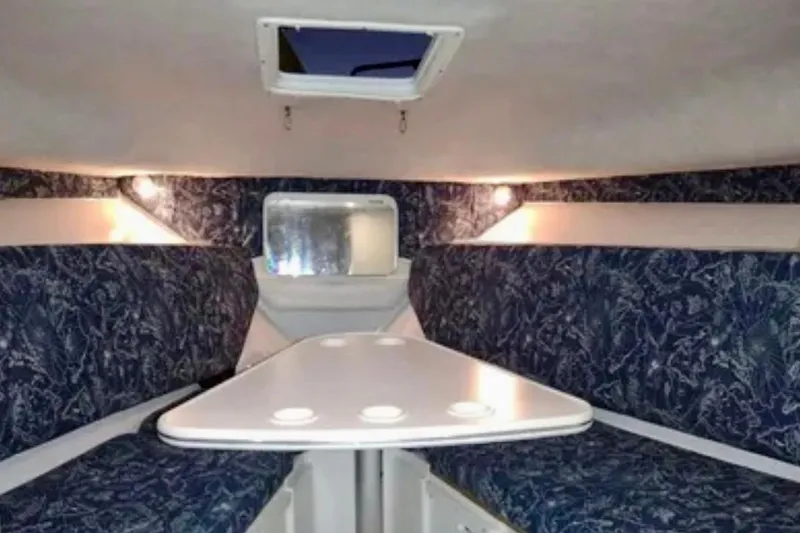 Slide: The Image of 2002 Wellcraft 290 Coastal cabin interior with patterned seating and a central table. - 25