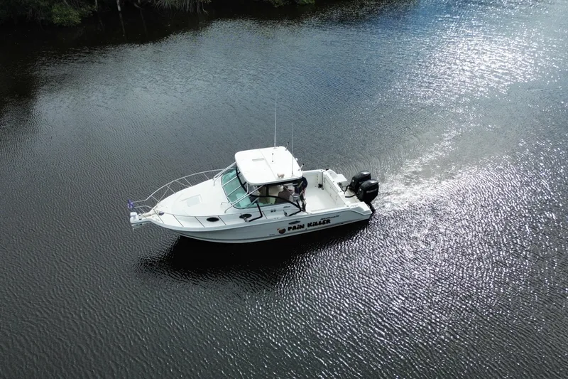 Slide: The Image of 2002 Wellcraft 290 Coastal boat cruising on a calm, reflective water surface. - 3