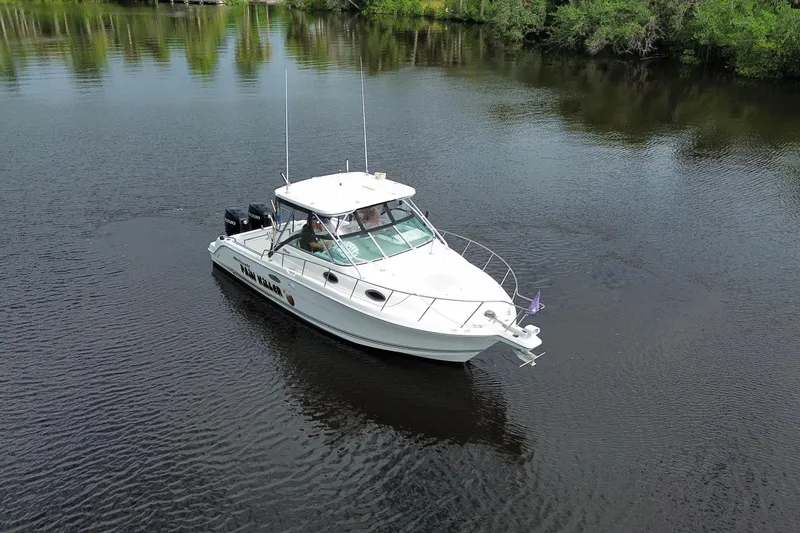 Slide: The Image of 2002 Wellcraft 290 Coastal boat cruising on a calm river surrounded by greenery. - 8