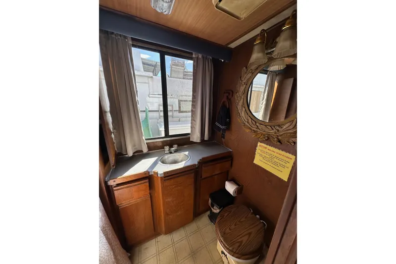 Slide: The Image of Vintage 1987 Hilburn 14x45 bathroom with wooden cabinets and decorative mirror. - 12
