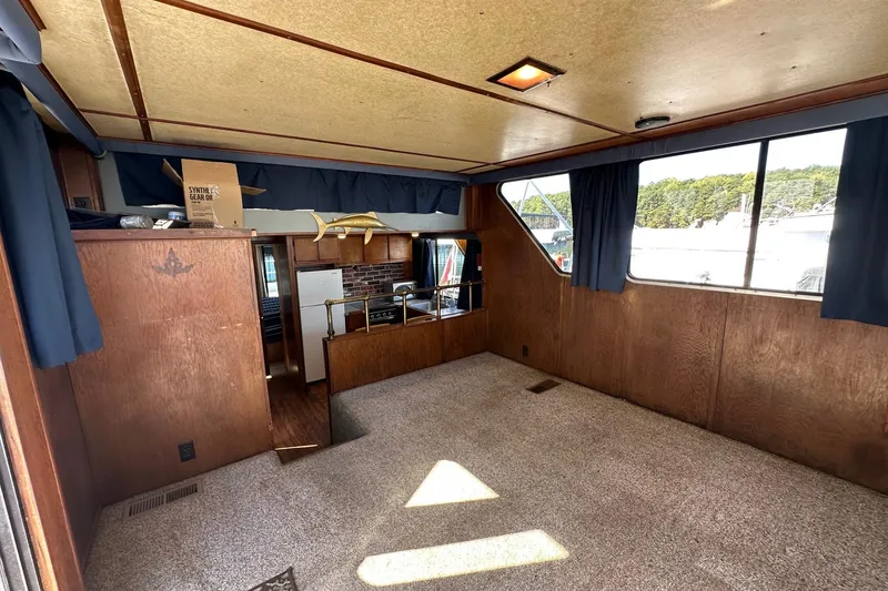 Slide: The Image of Interior of a 1987 Hilburn 14x45 houseboat with wood paneling and carpeted floor. - 4
